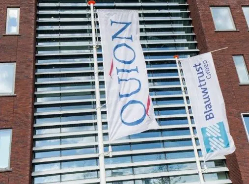 Hoofdentree van het gebouw van Quion met vlaggen voor de deur.